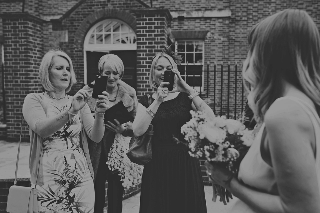 Captured moment friends taking pictures of Portsmouth bride