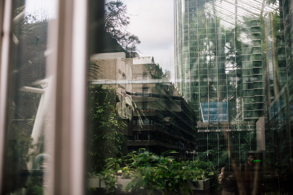 reflection of the city in the barbican conservatory