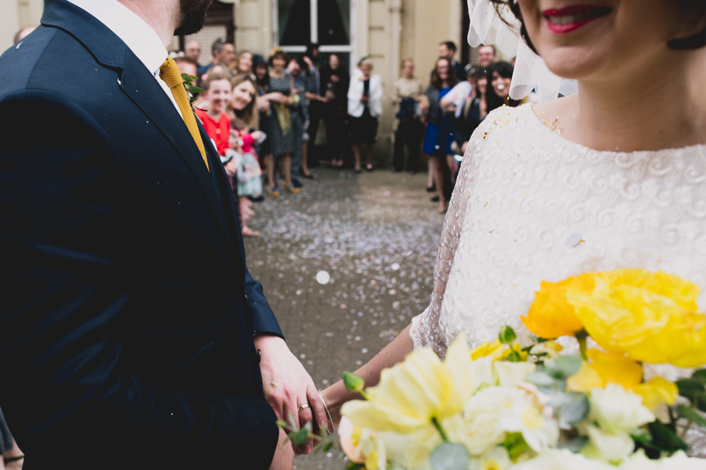bride and groom holding hands after confetti throw outside Brighton Town Hall Wedding
