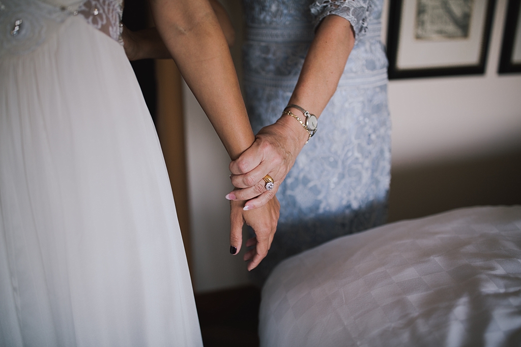 mum holding brides hand the morning of her wedding
