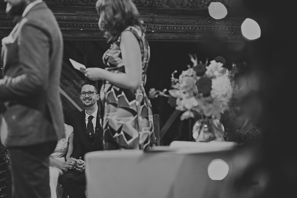 groom smiling during a a reading at a wedding ceremony at Wiltons Music Hall