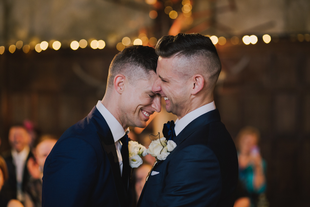 Two grooms laughing during a weddin ceremony at Battersea Arts Centre | Lisa Jane Photography | Modern London Wedding Photography