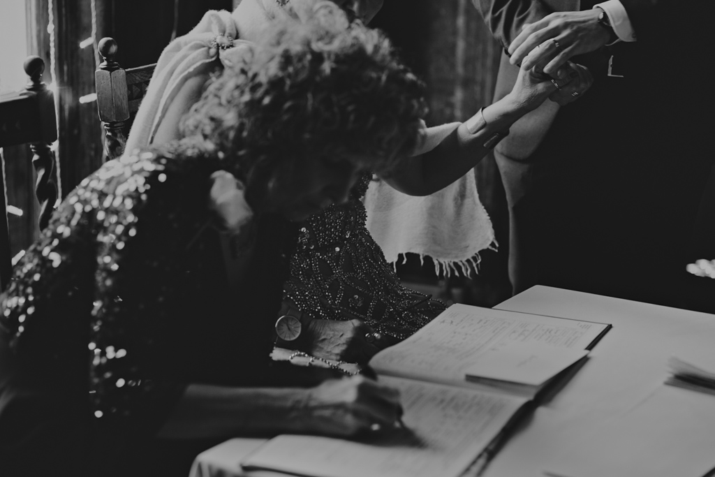 Holding hands during signing of the regisiter at a Battersea Arts Centre wedding | Lisa Jane Photography | Modern London Wedding Photography