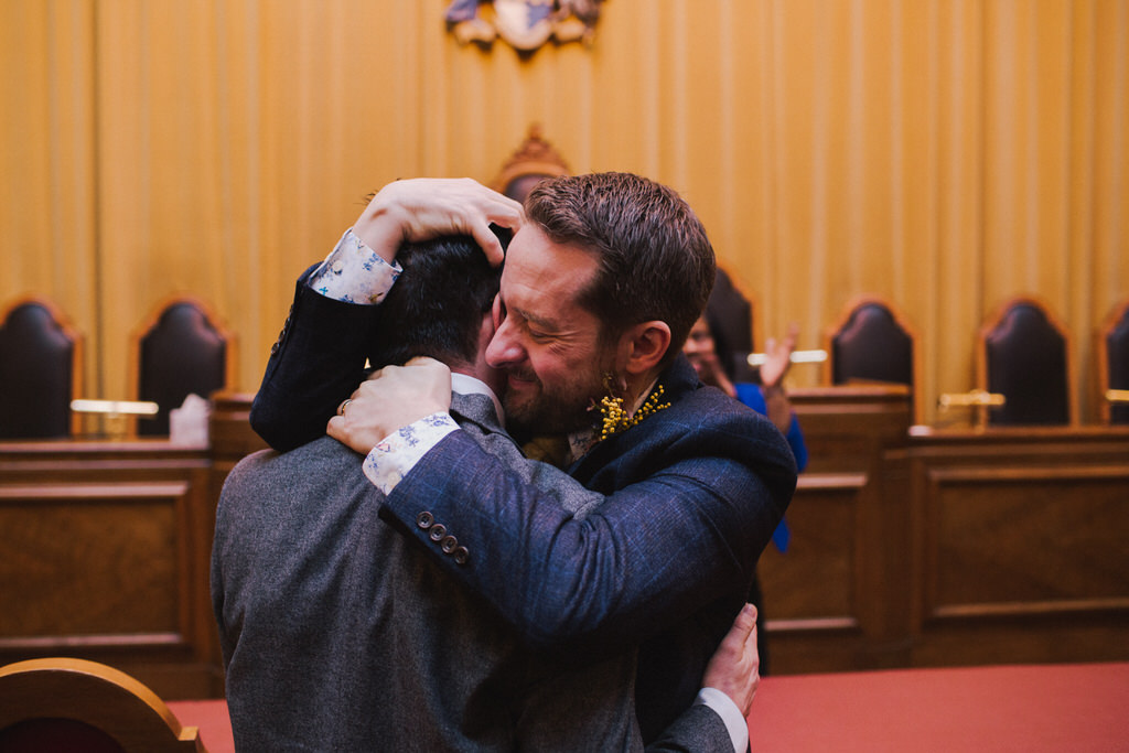 Two grooms hugging at Wandsworth Town Hall wedding