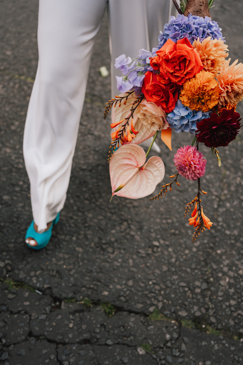 colourful wedding bouquet by Sage Flowers carried by bride walkting through the streets of London